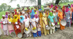 Women wait for work on the first day of the launching of the NREGA scheme at village Alamgarh near Abohar