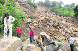 Workers clear the road blocked due to a landslide at Barog on Thursday.