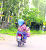 A pillion rider carries essential commodities after curfew was relaxed in Rajouri 