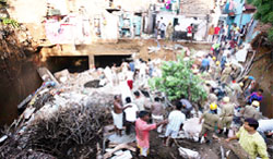 Fire personnel carry out resuce work at the site where a house collapsed near Prithviraj Road in New Delhi