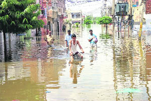 People come out of the Old Housing Board Colony, which was badly affected due to floods in Bhiwani, on Saturday.