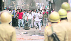 Protesters hurl stones at the police during a demonstration in Srinagar on Saturday.