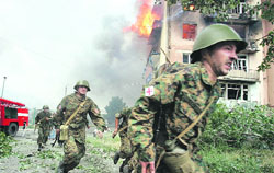 Soldiers run near a blazing apartment after a bombardment in the town of Gori, 80 km from Tbilisi
