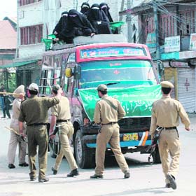 Policemen smash the windowpanes of a minibus carrying Kashmiri women agitators during a protest march to Muzaffarabad in Srinagar