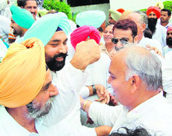PPCC working president Mohinder Singh Kaypee (right) reaches out to embrace expelled leader of the Congress Harjinder Singh Thekedar in Amritsar on Sunday. 