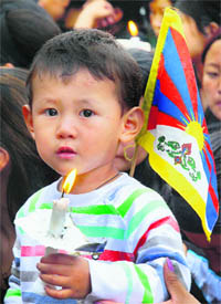 A Tibetan boy holds a candle during a protest march in Shimla.