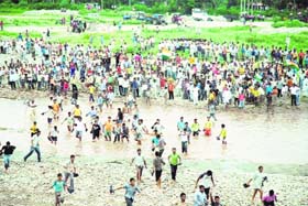 Agitators cross Tawi river near Phallian Mandal on Tuesday to reach Jammu for staging demonstrations