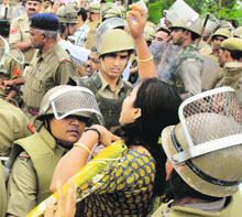 The police tries to control a woman protester during a road blockade by activists of the BJP and the VHP at Liberty Chowk in Karnal on Wednesday.