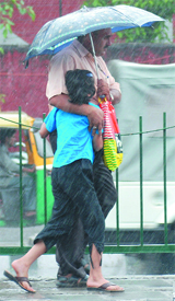 A man protects his child from the heavy rains in New Delhi on Thursday.