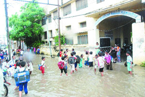 Students of government school, Basti Sheikh, wade through knee-deep water in Jalandhar.