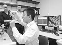 Jie Yao, right, co-author of a science paper about new materials that can bend light backwards, gives a brief demonstration as co-authors Guy Bartal, left, Jason Valentine, center, look on during a news conference in a laboratory at the University of California at Berkeley in Berkeley, Calif