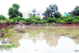 The rain water stagnant in the 10-feet deep trench poses a threat to residents and property as it has lead to eroding of earth.