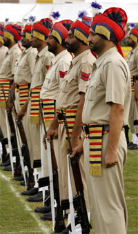 Policemen stand in attention with their arms during the ceremony.