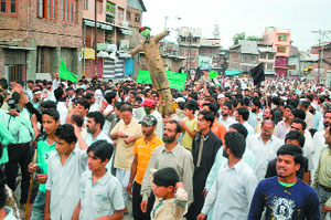 Muslim protesters take out a march in Srinagar holding aloft an effigy of a security personnel on Friday. 