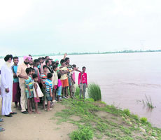 People of Manjli village in Moga district show the rising level in the Sutlej on Friday. 