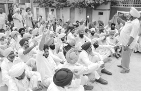 Members of the Kisan Action Committee stage a dharna in front of the house of Raj Khurana, Rajpura MLA, in Patiala, against the acquisition of 1078.16 acres of fertile land for the proposed super thermal plant near Nalash village on Saturday.