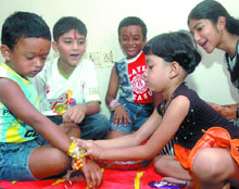 A little sister ties a rakhi while others look on, on the occasion of Raksha Bandhan in New Delhi on Saturday.