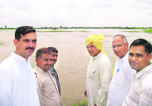 Haryana Janhit Congress (BL) leader Krishan Murti Hooda along with party colleagues visits waterlogged fields in Mokhra village in Rohtak district on Saturday.
