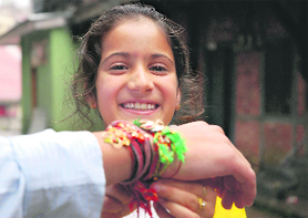 This girl is all smiles as she ties a rakhi on the wrist of her brother in Shimla on Saturday.