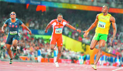 Usain Bolt (R) of Jamaica crosses the finish line ahead of Richard Thompson (C) of Trinidad and Tobago and Walter Dix (L) of the US to win the mens 100m final in the athletics competition at the National Stadium