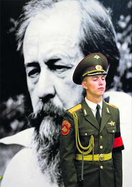 A soldier stands in front of a portrait of late Russian writer Alexander Solzhenitsyn in Moscow.