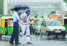 A traffic policeman tries to restore order in rain at ITO crossing in New Delhi