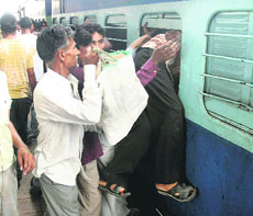 Migrant labourers scramble for seats on the Jammu Tawi- Hatia Express at Jammu railway station on Sunday. 