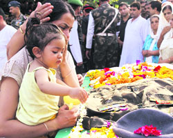 Son of Major Padmanabhan offers flowers petals on his fathers coffin during the cremation ceremony in Jammu on Sunday. 