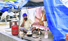 A family marooned in the floodwaters at Gidderpindi village makes a temporary kitchen on the rooftop of their house.