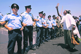 An Ethiopian immigrant (right) holds up a photograph of a relative in front of Israeli police officers during a protest near the office of Prime Minister Ehud Olmert in Jerusalem on Sunday. Around 1,000 Israelis of Ethiopian descent took part in a demonstration on Sunday calling on the Israeli government to grant permission for their relatives living in Ethiopia to immigrate.