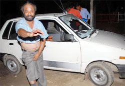 Kuldeep Singh, a government teacher, standing besides his damaged car, shows the injuries he received after being beaten up by some miscreants near the Rose Garden in Bathinda on Monday night. The windscreen of his car was also smashed. He complained to the police that his brother-in-law, a political activist, was behind the incident. Police is investigating into the matter.