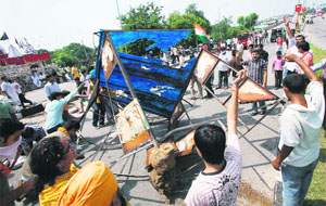 Demonstrators damage a police booth during a protest held in Jammu on Monday as part of the Jail bharo call given by the Amarnath Sangharsh Samiti.