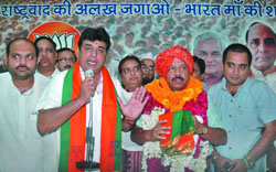 Formr SP leader Jameel Anjum accompanied by 150 supporters from Jama Masjid and Chandni Chowk with Delhi Pradesh BJP president Harsh Vardhan during their joint press conference at the Delhi Pradesh BJP party office in New Delhi on Tuesday. 