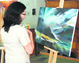 A visitor admires a painting put up by artists from other states at Himachal Pradesh University in Shimla on Tuesday.