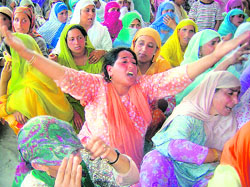 Muslim women mourn the death of truck driver Lateef Ahmad Wani, who was reportedly killed when his vehicle was attacked with a petrol bomb, in Srinagar on Tuesday. 