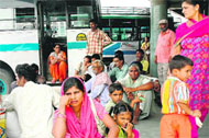 commuters wait at the Sector 17 local bus stand in Chandigarh on Wednesday.