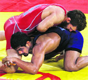 Sushil (in blue) fights Doug Schwab of USA during their freestyle repechage round 1 match