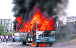 A bus set afire by an irate mob after a motorcyclist was crushed to death under it near Pehowa