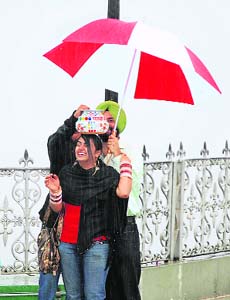 Tourists seem to enjoy in good weather during rain at the Ridge at Shimla
