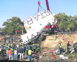 A part of the fuselage of the Spanair jet, which crashed at the Madrid airport on Wednesday, is lifted by a crane. 