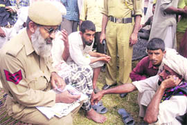 Migrant Gujjars get themselves registered for getting relief in Jammu on Friday.