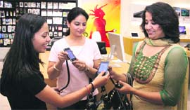 Curious residents enquire about the latest high-end phone launched by Apple at an outlet in a leading mall in Ludhiana. 