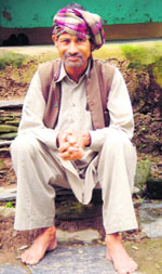 Tulsi Ram sitting on the stairs of his house. 