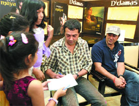 Actor brothers Sunny Deol and Bobby Deol sign autographs for children at a promotional function of their upcoming movie 'Chamku' in New Delhi on Sunday.