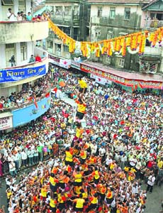 Devotees form a human pyramid to break a clay pot containing butter during Janmashtami celebrations in Mumbai