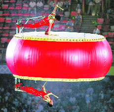 Participants perform on a drum suspended in the air during the closing ceremony.