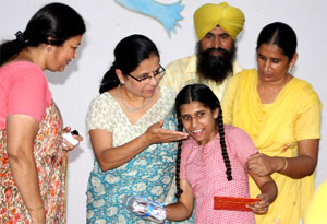 President of Chetak AWWA Rashmu Sujlana handing over prize to a physically challenged girl during the function.