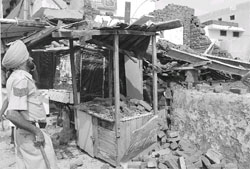 Employees of the Patiala Municipal Corporation raze an illegal structure at Gandhi Nagar Market