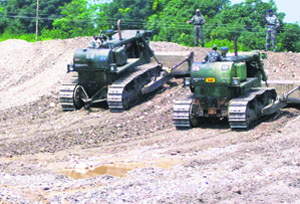 Army dozers recreating the river bank by repairing breaches which occurred due to flash floods in Chhonch rivulet on Monday. 