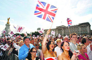 Crowds wave flags during a screening of the official handover of the Beijing Olympic Games to London in front of Buckingham Palace in London.